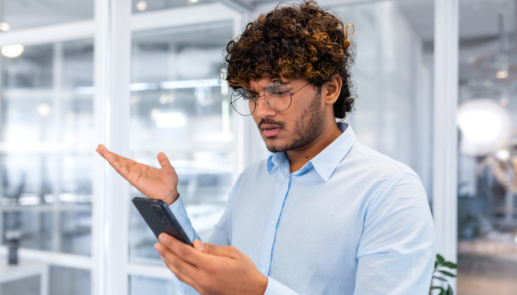 Close up of businessman in middle of office holding phone