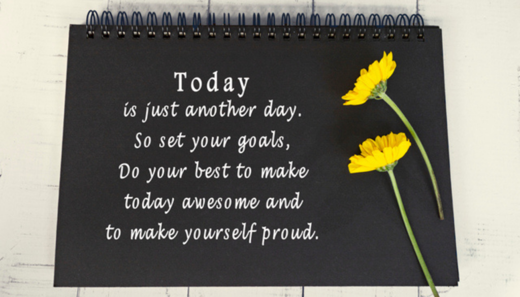 Motivational and inspirational quote on black note book with sunflowers.